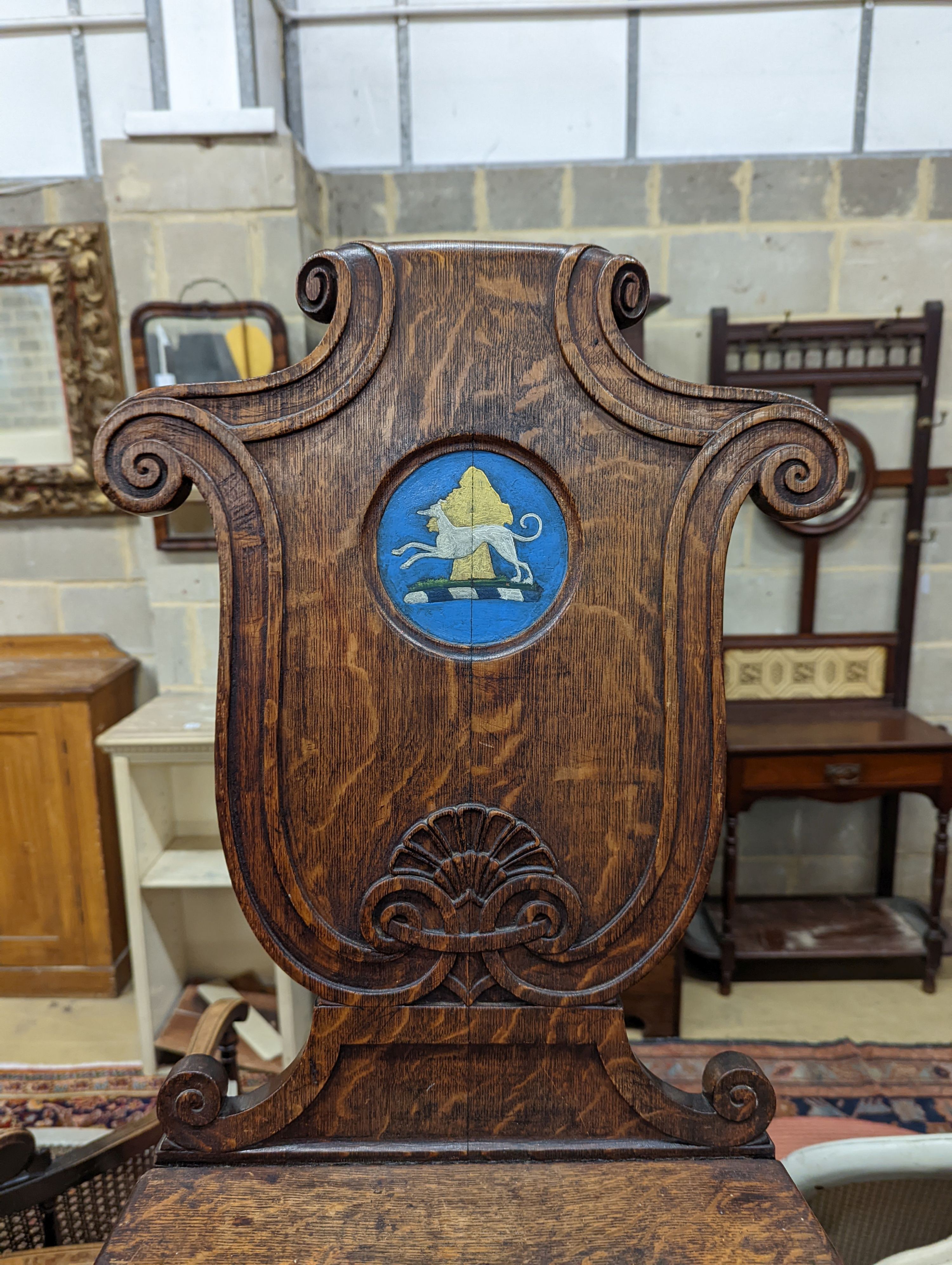 A pair of Victorian oak hall chairs with painted armorials, width 43cm, depth 39cm, height 94cm